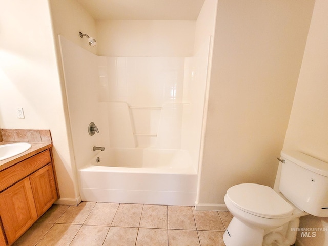 bathroom with toilet, vanity,  shower combination, tile patterned flooring, and baseboards