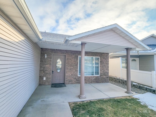 entrance to property with a patio area and fence