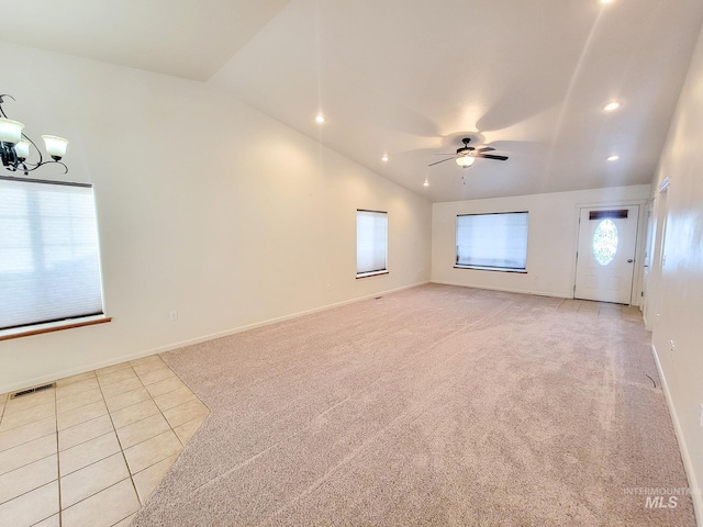 unfurnished living room featuring lofted ceiling, visible vents, light carpet, baseboards, and ceiling fan with notable chandelier