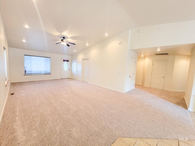 spare room with vaulted ceiling, a ceiling fan, and light colored carpet