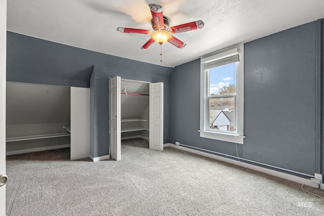 unfurnished bedroom with carpet flooring, ceiling fan, a textured ceiling, and lofted ceiling