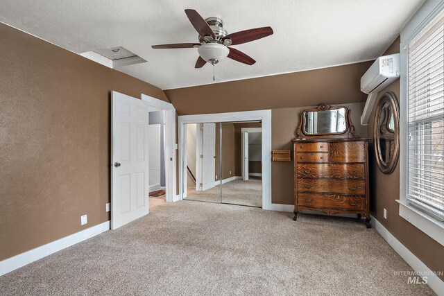 unfurnished bedroom with ceiling fan, a wall unit AC, vaulted ceiling, light carpet, and a closet