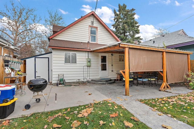 rear view of house with a patio and a fire pit