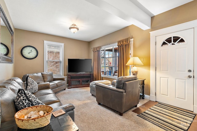 living room featuring beam ceiling and light carpet