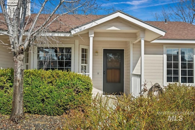 property entrance featuring roof with shingles