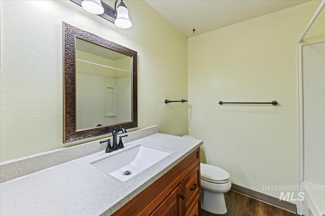 2429 Cherry St, Caldwell, ID 83605 - full bath with vanity, a shower, toilet, wood finished floors, and a textured wall