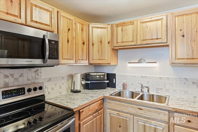 2429 Cherry St, Caldwell, ID 83605 - kitchen featuring stainless steel appliances, light brown cabinets, a sink, and tasteful backsplash