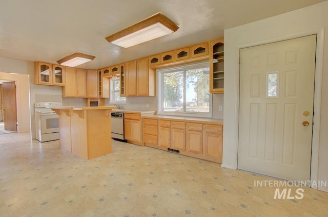 kitchen with a center island, light brown cabinets, white appliances, a kitchen breakfast bar, and sink