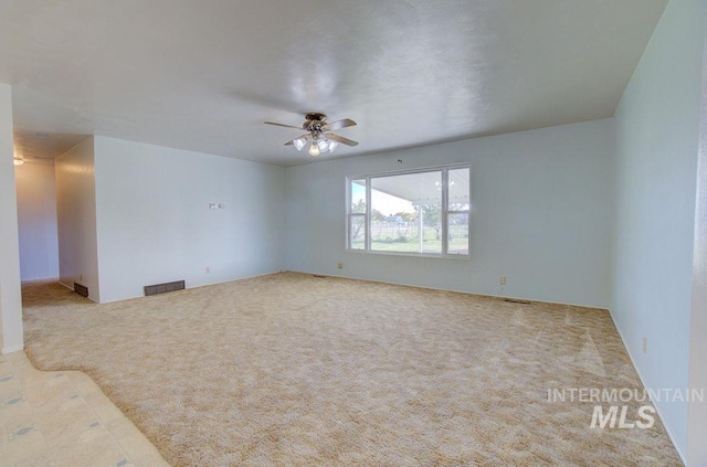 carpeted spare room featuring ceiling fan