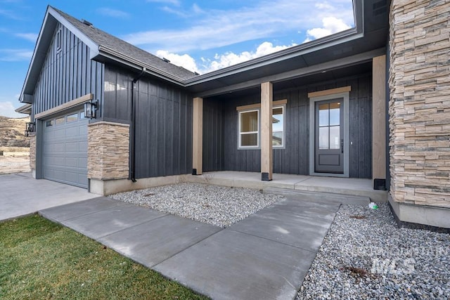 view of exterior entry featuring covered porch and a garage