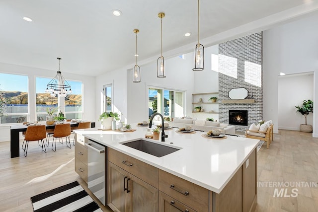 14241 N Woodpecker Ave, Boise, ID 83714 - kitchen with a sink, a fireplace, stainless steel dishwasher, light countertops, and a towering ceiling