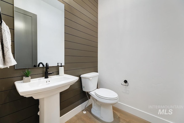 14241 N Woodpecker Ave, Boise, ID 83714 - bathroom with baseboards, wooden walls, toilet, and wood finished floors