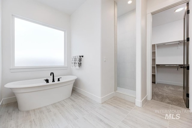 14241 N Woodpecker Ave, Boise, ID 83714 - full bathroom featuring a tile shower, baseboards, a freestanding bath, a walk in closet, and recessed lighting