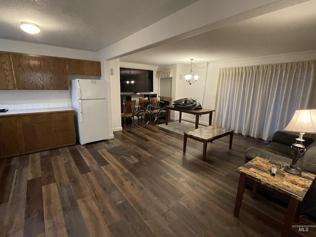 living room with a notable chandelier and dark wood-type flooring