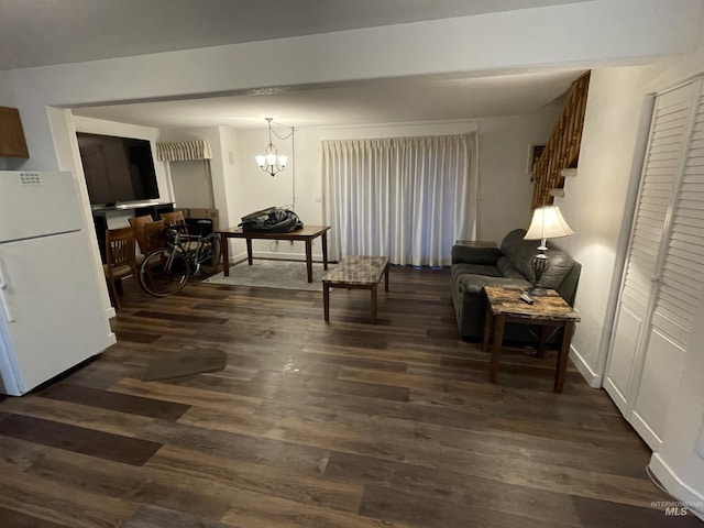 living room featuring dark wood-type flooring and an inviting chandelier