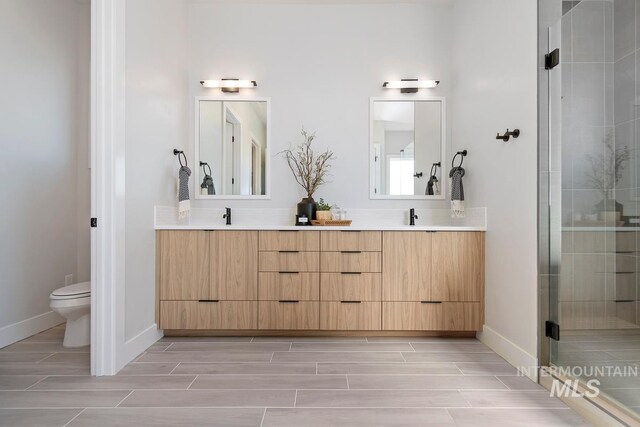 3501 E Planet Dr, Boise, ID 83712 - bathroom with double vanity, a stall shower, wood finish floors, and toilet