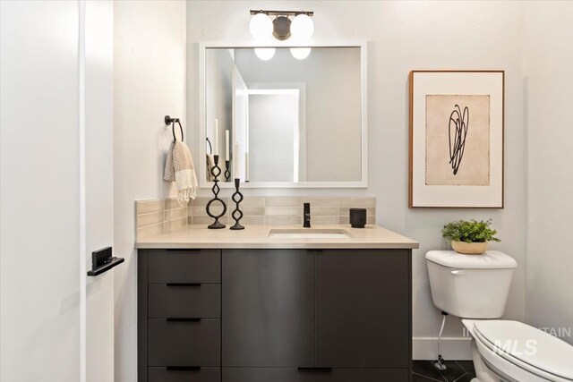 3501 E Planet Dr, Boise, ID 83712 - bathroom featuring toilet, vanity, tasteful backsplash, and baseboards