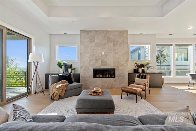 3501 E Planet Dr, Boise, ID 83712 - living area featuring wood finished floors, a tile fireplace, a tray ceiling, and recessed lighting