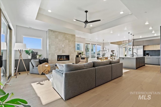 3501 E Planet Dr, Boise, ID 83712 - living room featuring recessed lighting, light wood finished floors, a raised ceiling, a fireplace, and ceiling fan