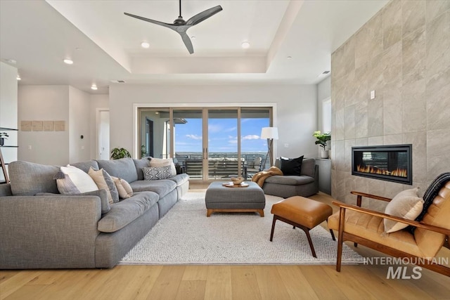3501 E Planet Dr, Boise, ID 83712 - living room with a raised ceiling, light wood finished floors, a ceiling fan, a tile fireplace, and recessed lighting