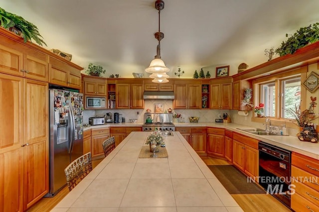 kitchen featuring tile counters, hardwood / wood-style floors, sink, and stainless steel appliances