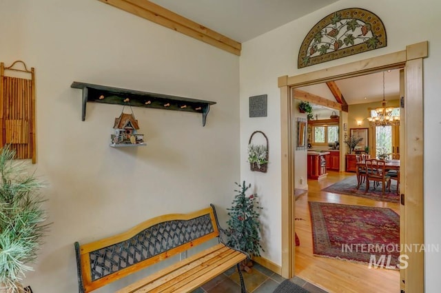 interior space with an inviting chandelier, wood-type flooring, and lofted ceiling