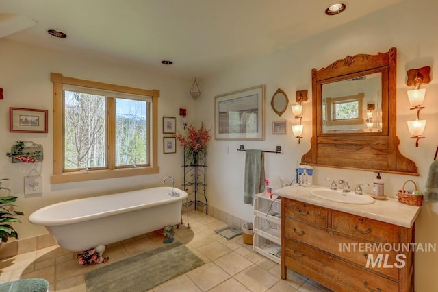 bathroom featuring plenty of natural light, tile flooring, a washtub, and large vanity