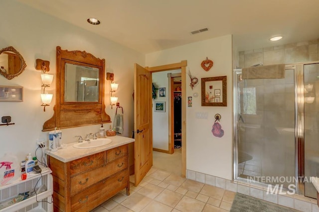 bathroom with vanity, walk in shower, and tile flooring