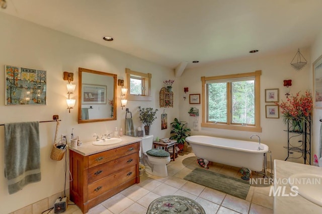 bathroom with a bathtub, large vanity, and tile flooring