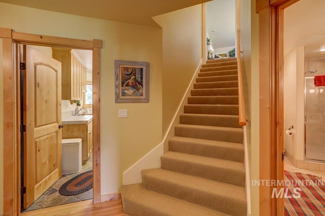 staircase featuring light hardwood / wood-style floors and sink