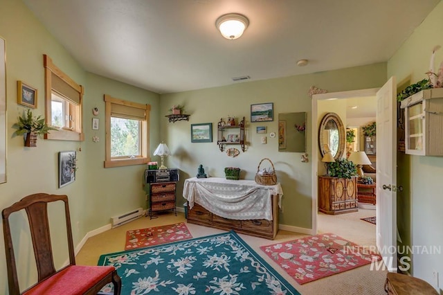 bedroom featuring light carpet and a baseboard heating unit