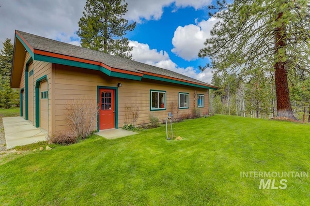 back of property with a yard and a garage