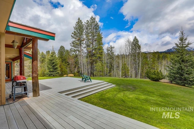 wooden terrace featuring a yard