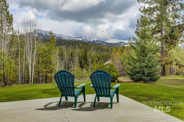 wooden deck with a lawn and a mountain view