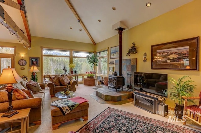 living room featuring high vaulted ceiling, light colored carpet, and a wood stove