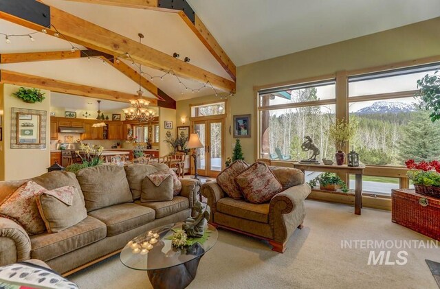 carpeted living room featuring beamed ceiling, high vaulted ceiling, and an inviting chandelier