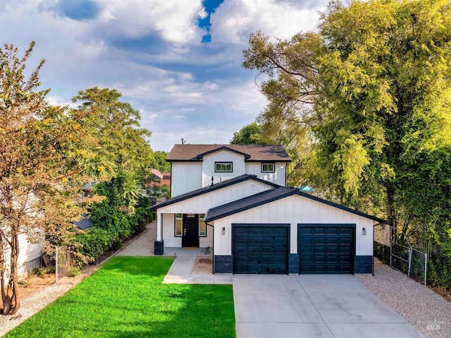 modern farmhouse style home with a front yard, fence, an attached garage, concrete driveway, and board and batten siding