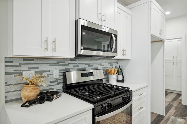 kitchen featuring stainless steel appliances, wood finished floors, white cabinets, and light countertops