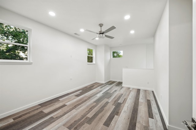 spare room with recessed lighting, baseboards, and wood finished floors