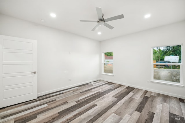 unfurnished room featuring plenty of natural light, recessed lighting, baseboards, and wood finished floors