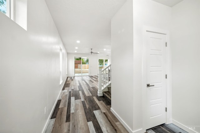 hallway with stairs, recessed lighting, baseboards, and dark wood-style flooring