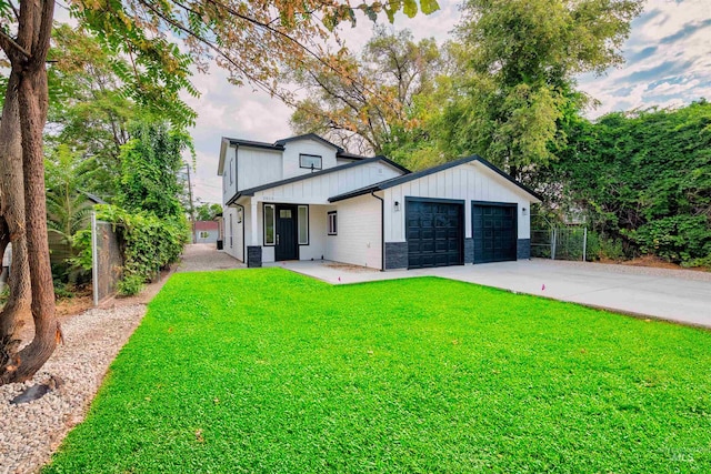 view of front facade featuring a front yard, fence, an attached garage, concrete driveway, and board and batten siding