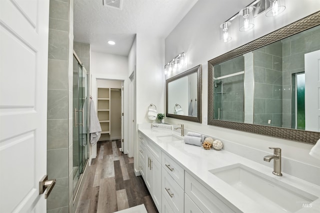 bathroom featuring a stall shower and a sink