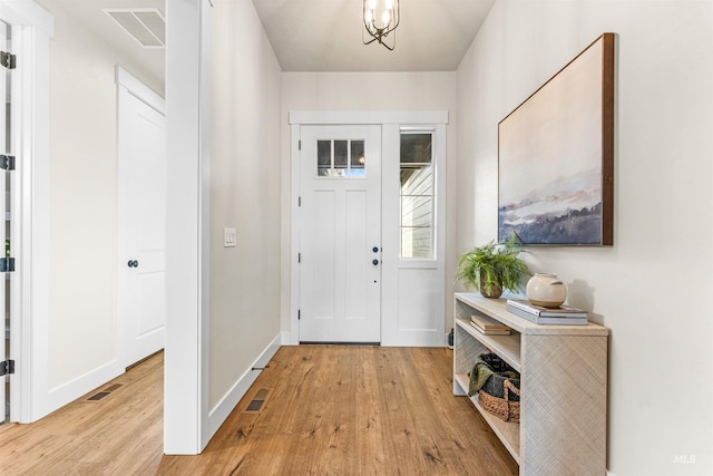 entryway with a chandelier and light wood-type flooring