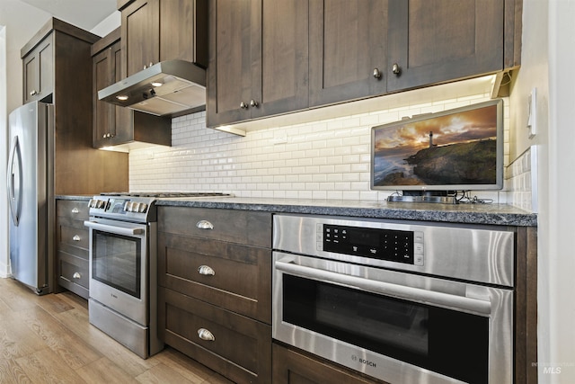 6164 N Winward Ln, Meridian, ID 83646 - kitchen featuring appliances with stainless steel finishes, light wood finished floors, range hood, dark brown cabinetry, and decorative backsplash
