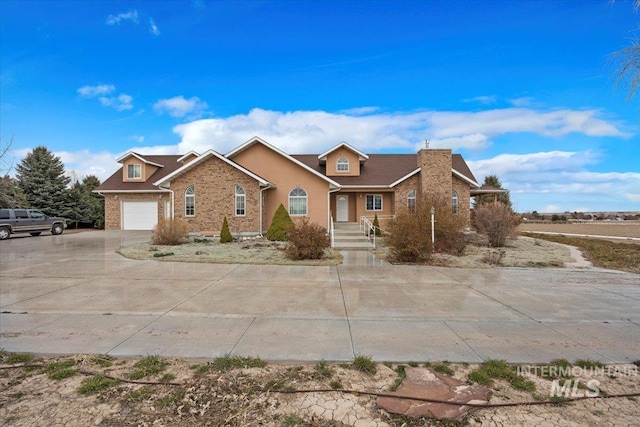 view of front of house with stucco siding, concrete driveway, and an attached garage