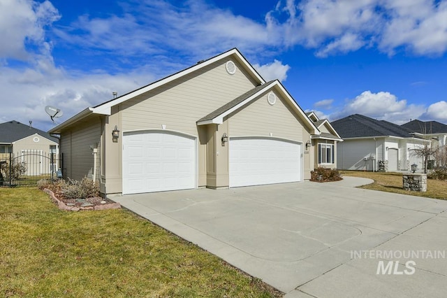 ranch-style home featuring an attached garage, fence, driveway, a residential view, and a front yard