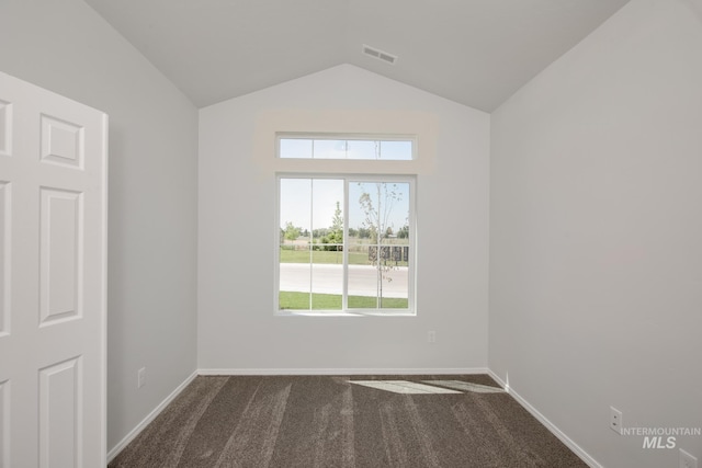 carpeted empty room with vaulted ceiling