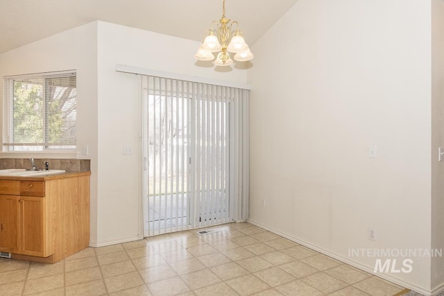 unfurnished dining area with visible vents, baseboards, a chandelier, vaulted ceiling, and a sink