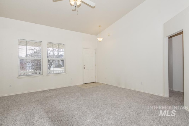 spare room featuring baseboards, light colored carpet, ceiling fan, and high vaulted ceiling